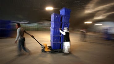 Workers transport ballot boxes on a trolley to be loaded on to trucks at the Independent Election Commission compound in Kabul, Afghanistan, Thursday, Oct. 22, 2009. 