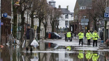 A man walks down Cockermouth High Street, where flood water has receded after torrential rain caused rivers to burst their banks, Cockermouth, Cumbria, England, Saturday, Nov. 21, 2009. 
