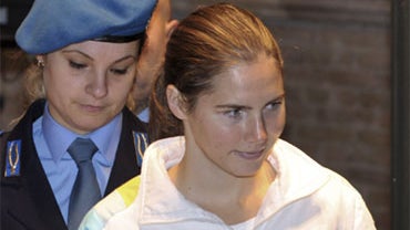 U.S. murder suspect Amanda Knox, right, is escorted by an Italian penitentiary police officer at a hearing in Perugia's court, Italy, Saturday, Nov. 28, 2009. 