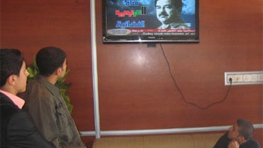 Iraqi men at a coffee shop watch the Saddam Channel, showing the former Iraqi dictator Saddam Hussein, in his hometown in Tikrit, 100 miles north of Baghdad on Sunday, Nov. 29, 2009. 