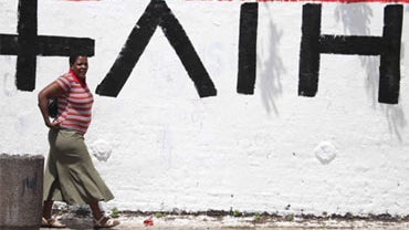 A woman passes HIV+ written upside-down on a graffiti wall on World AIDS Day in Johannesburg Tuesday, Dec. 1, 2009. There has been a strong drive by businesses and the public and private sectors to create an awareness of HIV and AIDS in a country that has 