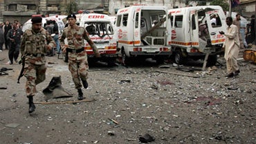 Soldiers of Pakistani para-military rush to the site of a bomb blast 