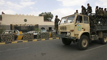 A September 18, 2008 file photo shows Yemeni soldiers on top of a truck patroling the road in front of the main entrance of the U.S. Embassy in the capital San'a. 