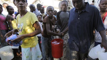 Earthquake survivors carry buckets they filled with water from a water distribution truck in Port-au- Prince, Haiti, Friday, Jan. 15, 2009. 