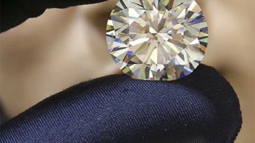 A saleswoman displays a 26.62 carat diamond, valued at $5.3 million, at a shopping center in Nanning, China, Nov. 27, 2006. (Reuters/China Daily) 