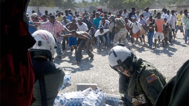 In this photo released by the U.S. Navy, Haitian citizens receive water from air crewmen from Helicopter Sea Combat Squadron 9 assigned to the aircraft carrier USS Carl Vinson, Saturday, Jan. 16, 2009 in Port-au-Prince, Haiti. 