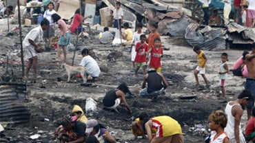 Residents sift through the debris following an overnight fire that razed through a squatters' community of Baseco near a Manila port Sunday Jan. 17, 2010, in the Philippines. 
