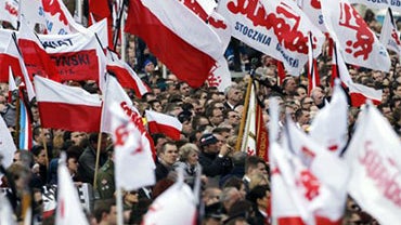 Mourning people hold Polish national flags and flags of the Solidarity union during a national memorial service in Pilsudski Square in Warsaw on Saturday, April 17, 2010 in Warsaw, Poland. Polish President Lech Kaczynski was killed in a plane crash in Rus 