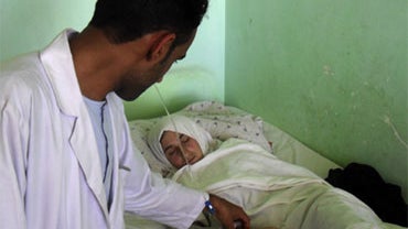 A medic checks on a schoolgirl in a hospital in Kunduz ,north of Kabul, Afghanistan, Sunday, April 25, 2010.  