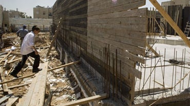An Ultra-orthodox Jewish boy climbs on timber beams at a construction site in the east Jerusalem neighborhood of Ramat Shlomo, Monday, April 26, 2010.  