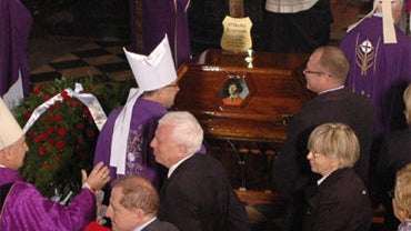 People and priests gather beside the coffin with the remains of astronomer Nicolaus Copernicus, in the catherdral in Frombork, northern Poland, Saturday, May 22, 2010. 
