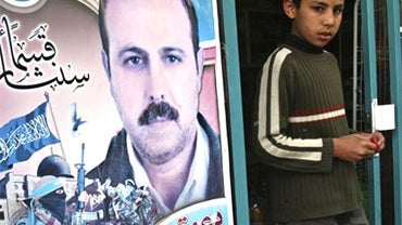 In this March 24, 2010 file photo a Palestinian youth walks out of a store covered with posters of of assassinated Mahmoud al-Mabhouh, one of the founders of Hamas military wing, near his family house in Beit Lahiya, northern Gaza Strip. A spokesman for G 