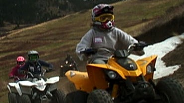 Unidentified children ride ATVs. 