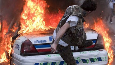 A protester kicks a burning a police car burns during an anti-G20 demonstration in Toronto Saturday, June 26, 2010 in Toronto. during an anti-G20 demonstration Saturday, June 26, 2010 in Toronto. (AP Photo/The Canadian Press, Ryan Remiorz) 
