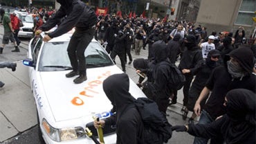 Activists attack a police car in Toronto's financial district during the G20 Summit Saturday, June 26, 2010. 
