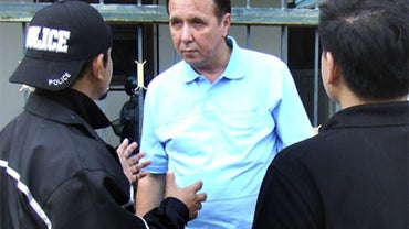 Mikhail Vasillievich Pletnev, Center, is Questioned by a Thai Police Officer (AP Photo) 