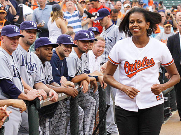 Michelle Obama jogs away after greeting members of the Tampa Bay Rays after taking part in the ceremonial first pitch before the start of a baseball game. 