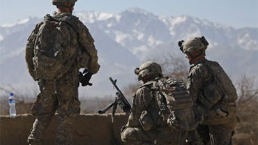 Soldiers belonging to the Able Troop 3-71 Cavalry Squadron wait in front of a school in the town of Baraki Barak district, Logar province, Afghanistan Thursday Nov. 26, 2009. 