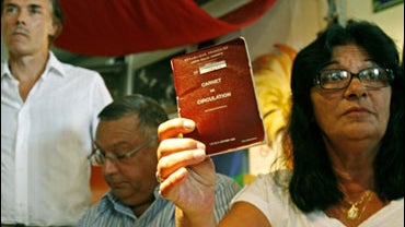 Alice Januel, displays an official document which authorizes French Romanies to travel with their caravan 