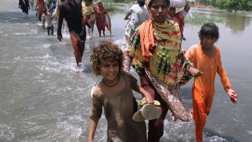 A Pakistani man carries his child and household items through floodwaters in Sujawal in southern Sindh province, August 30, 2010. 
