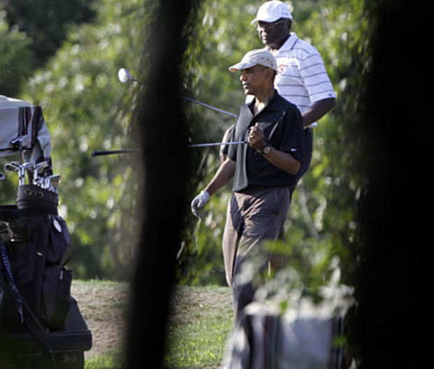 President Barack Obama, center, returns to his golf cart while playing at the Vineyard Golf Club, in Edgartown, Mass., on Aug. 20, 2010. House Majority Whip Jim Clyburn of South Carolina, walks with the president at right. 