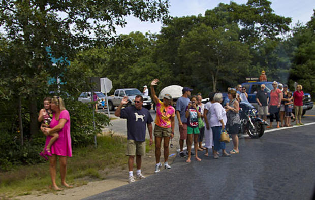 People wave as the motorcade of President Barack Obama passes Aug. 21, 2010, in West Tisbury, Mass. (Photo by Rick Friedman-Pool/Getty Images)  