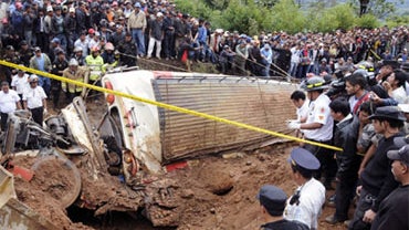 People surround a bus after it was covered by a landslide killing ten people on September 4, 2010 on the Interamericana road, Tecpan municipality, Chimaltenango, Guatemala. 