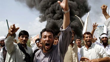 Afghans shout anti-U.S. slogans as they burn tires and block a highway during a protest in reaction to a small American church's plan to burn copies of the Quran, at Jalalabad, east of Kabul, Afghanistan, Sept. 10, 2010. Two people were killed on a third  