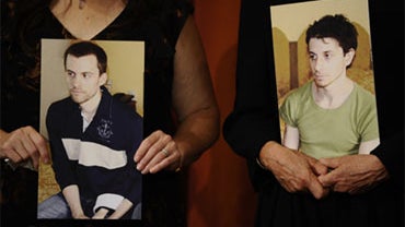 Pictures of two American hikers detained in Iran - Shane Bauer, left, and Josh Fattal - are held by their mothers, Cindy Hickey and Laura Fattal, during a press conference in New York, Sept. 19, 2010.  