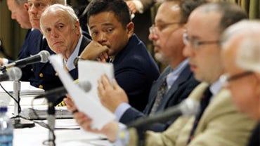 Deepwater Horizon joint investigation board members, from the left, U.S. Coast Guard Lt. Robert Butts, Capt. Mark Higgins, Wayne Andersen, U.S. District Judge (Ret.), Capt. Hung Nguyen, David Dykes, Jason Mathews and John McCarroll look through documents  