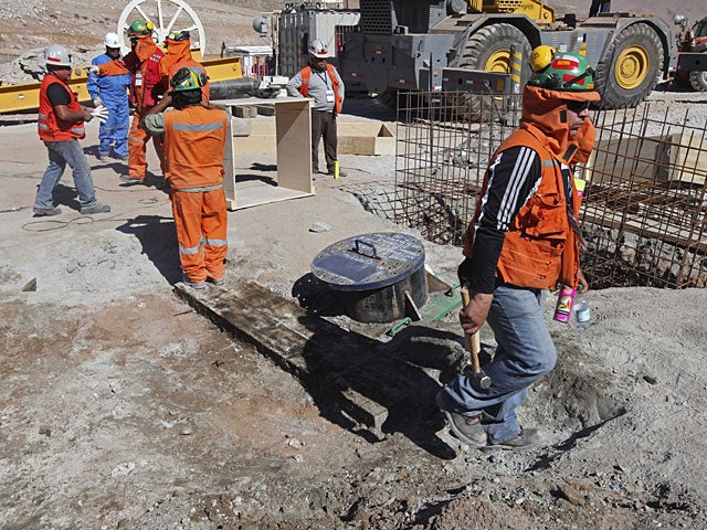 this image released by the government of Chile, workers at the San Jose mine work next to the covered entrance to the tunnel, center, that was drilled for the rescue operation of 33 miners trapped inside the mine near Copiapo, Chile, Monday, Oct. 11, 2010 