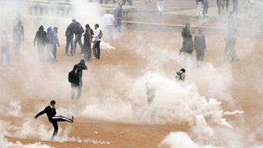 High school students in Lyon protect themselves from tear gas during a demonstration against the French government's proposed pension reform, October 19, 2010.  
