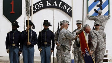 U.S. soldiers fold a flag during a transfer of command ceremony for the Kalsu Forward Operating Base, south of Baghdad, on September 30, 2010 from the 3rd Advise and Assist Brigade, 3rd Infantry Division to 3rd Armored Cavalry Regiment (ACR). 