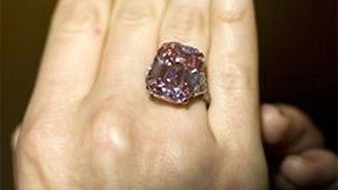 A Sotheby's employee displays a 24.78 carat fancy intense pink emerald-cut diamond ring during an auction press preview at Sotheby's in Geneva, Switzerland, Wednesday, Nov. 10, 2010. The ring will be offered on sale Nov. 16, 2010 with a pre-sale estimate  
