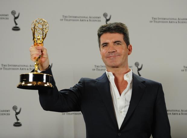 British television producer Simon Cowell holds The Founders Award at the at the 2010 International Emmy Awards November 22, 2010 in New York. AFP PHOTO/Stan Honda (Photo credit should read STAN HONDA/AFP/Getty Images)  