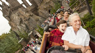 In this handout photo provided by Universal Orlando, Academy award-winning actors Michael Douglas and wife Catherine Zeta-Jones along with their children Dylan, 10, and Carys, 7, fly over The Wizarding World of Harry Potter and past Hogwarts Castle while  
