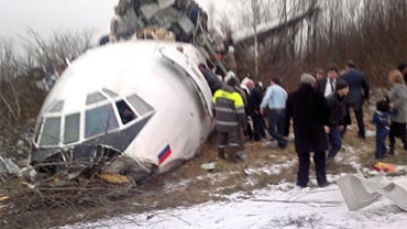 Passengers and rescuers gather near the crashed Dagestan Airlines Tupolev Tu-154 plane on December 4, 2010 at the Domodedovo airport outside of Moscow.  