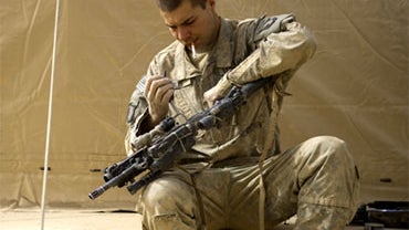 US Private First Class Edgar Ables of the 502nd Infantry regiment 2nd Batallion 1st Platoon Alpha Company, cleans his weapon in Ahmed Khan camp in Zari district of Kandahar city on December 5, 2010. Some 100,000 US troops are fighting in Afghanistan as pa 