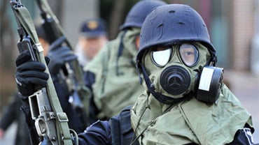 South Korean policemen wearing gas masks stand guard during a civil defence drill at an apartment village in Paju near the Demilitarized Zone (DMZ) separating the two Koreas, on December 15, 2010. 