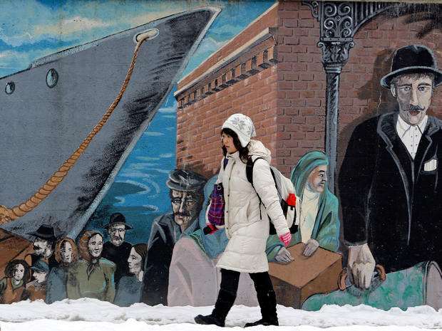 Eileen Lai, 21, walks back home past a mural in Little Italy,  Jan. 14, 2011, in Cleveland. 