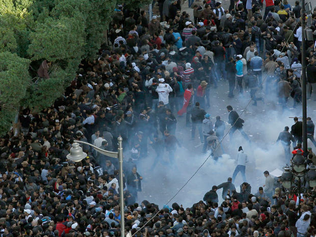 Demonstrators scatter after police officers use teargas during a protest in Tunisia, Jan. 14, 2011 