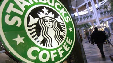 FILE - In this Nov. 10, 2008 file photo, a man pulls a cart past a Starbucks store in Beachwood, Ohio. Starbucks will begin a phased-in nationwide rollout Tuesday of its Trenta cup size that can be filled with just shy of a quart's worth of iced beverages 