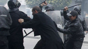 Riot police officers hit a protestor after a demonstration against the Constitutional Democratic Rally, RDC, party, of Ben Ali in the center of Tunis, Tuesday, Jan. 18. 2011. 