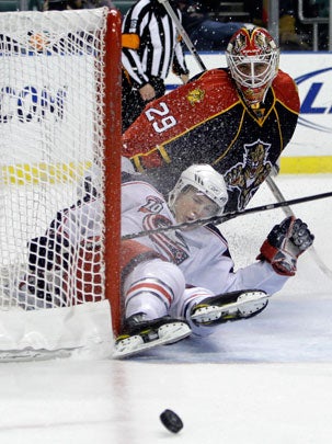 Blue Jackets' Matt Calvert, bottom, slides into the goal 