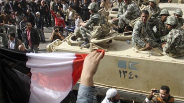 Egyptian protesters greet army soldiers atop their vehicles carrying a Egypt flag in central Cairo, Egypt, Saturday, Jan. 29, 2011. 