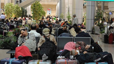 Tourists and Egyptians stranded at Cairo's international airport sleep late on January 29, 2011 as they can't leave the airport due to the curfew being brought forward in the Egyptian capital following anti-government riots. 