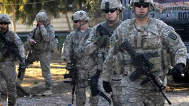 U.S. soldiers walk toward the scene of an explosion in Kandahar, south of Kabul, Afghanistan on Monday, Feb. 7, 2011. A bomb exploded in southern Afghanistan's largest city of Kandahar on Monday, killing at least one person and wounding two, Afghan offici 