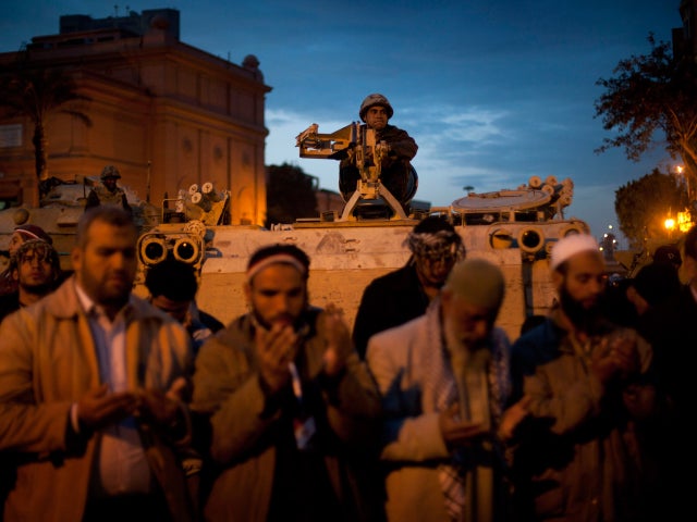 Egyptian soldier watches as protesters pray 