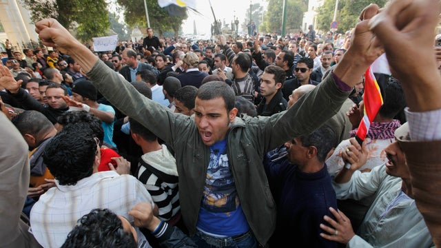 Demonstrators try to prevent Egyptian policemen, background, from marching inTahrir Square in Cairo, Egypt. 