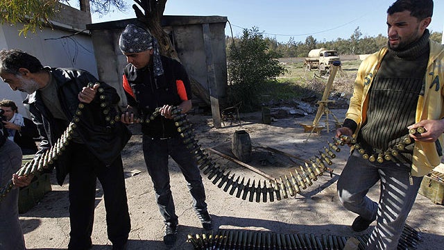Anti-Libyan Leader Muammar Qaddafi gunmen load bullets for heavy machine gun at a military base where they collect the anti-aircraft machine guns to maintain and prepare them for any attack come from the west country, in Benghazi. 